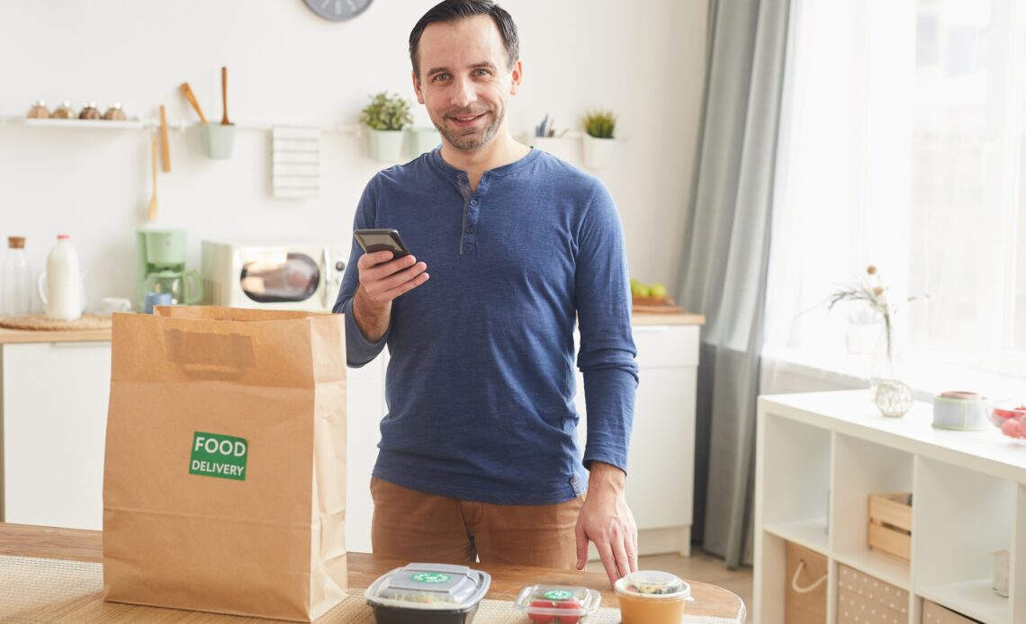 Smiling Man Enjoying Food Delivery Service
