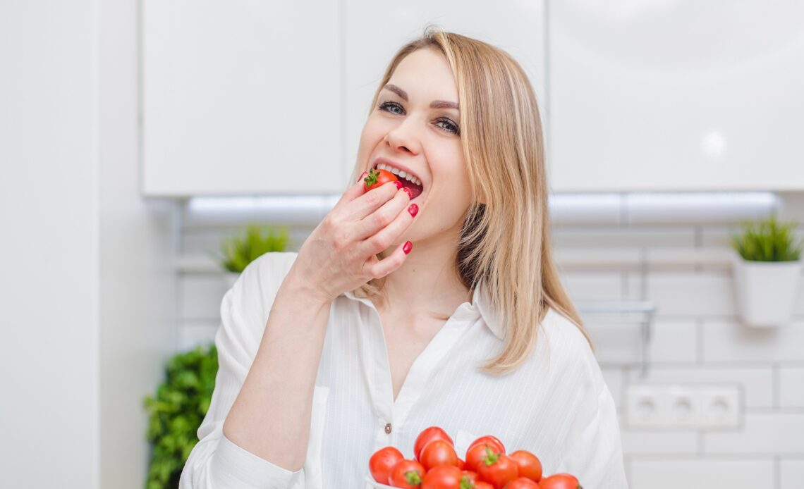 Woman eating tomato