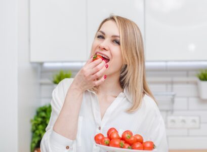 Woman eating tomato