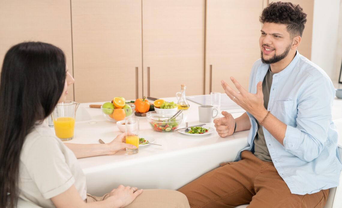 Young couple talking by breakfast